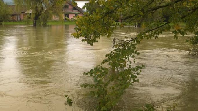 充满泥泞洪水的强大而奔腾的河流溢出河岸