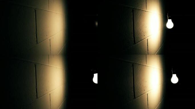 灯泡在黑暗的房间里靠墙摇摆