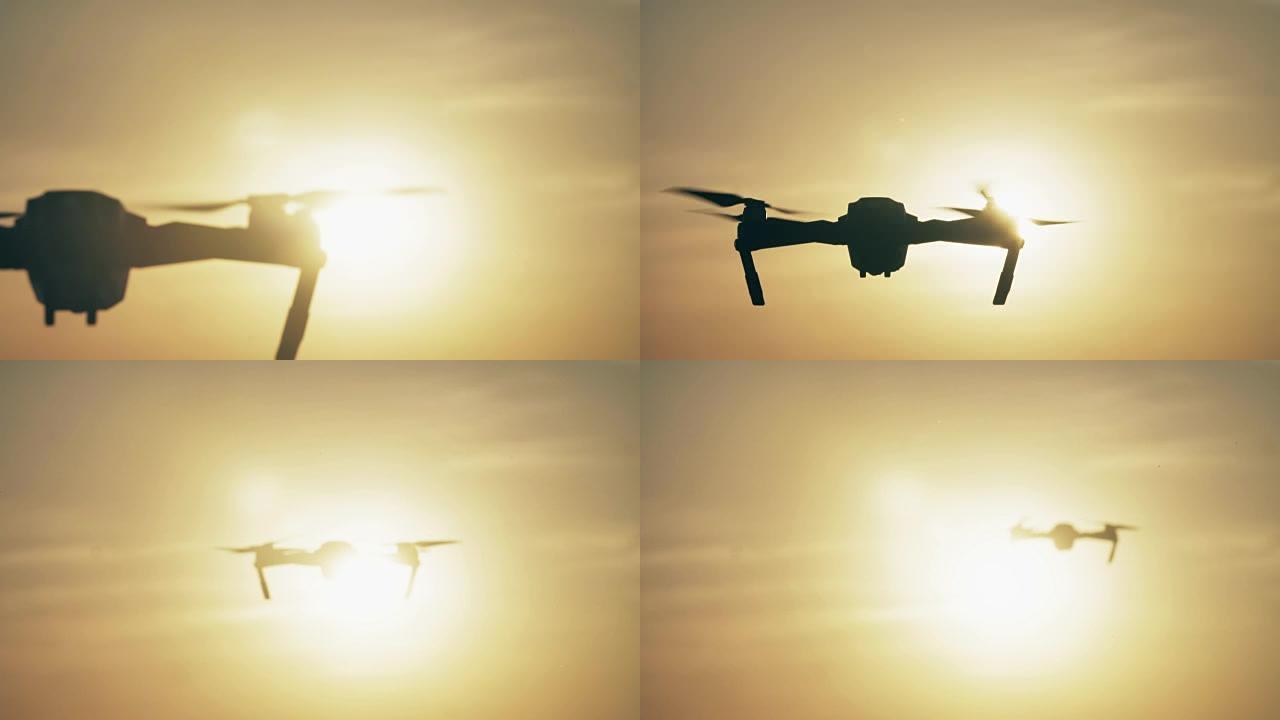 四轴飞行器。无线电控制的无人机飞行器在日落时飞走。