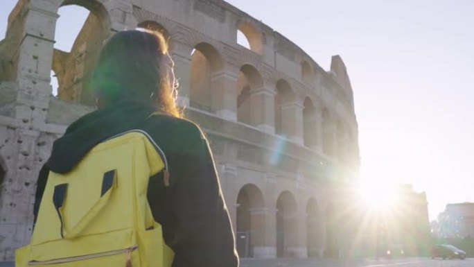 在欧洲罗马罗马斗兽场参观意大利著名地标的快乐年轻女性游客的后视图。体验旅行与多样性。与阿尔法。