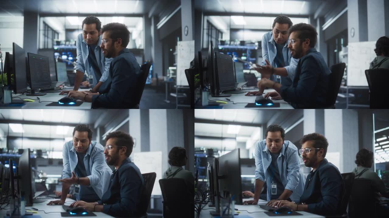 印度专家的创意团队在计算机旁边的工作场所进行对话。两名男性软件工程师讨论他们的数字区块链开发项目的软