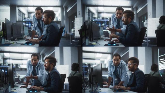 印度专家的创意团队在计算机旁边的工作场所进行对话。两名男性软件工程师讨论他们的数字区块链开发项目的软
