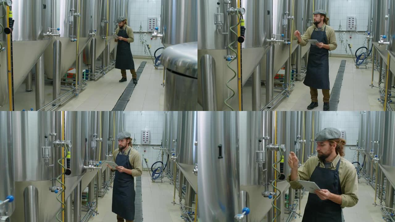 高加索男性啤酒厂工人检查啤酒罐上的压力表