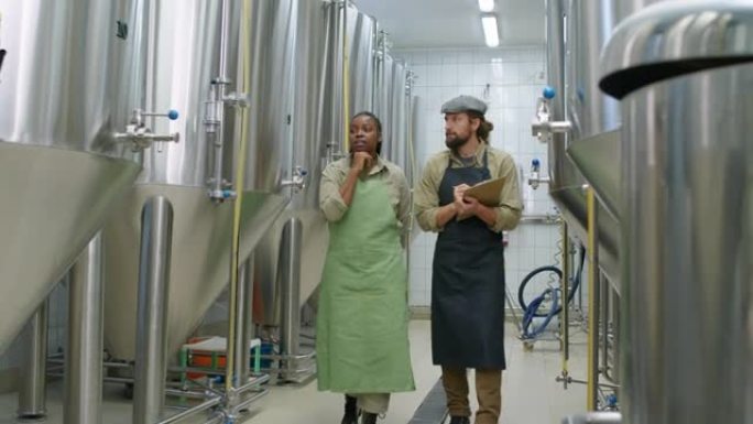 跨国啤酒厂员工检查啤酒发酵罐