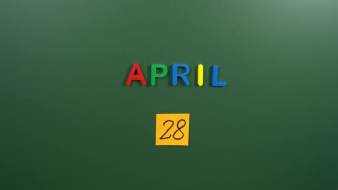 4月28日日历日用手在学校董事会上贴一张贴纸。28 4月日期。4月第二十八天。第28个日期号。28天