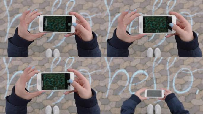 使用智能手机拍摄粉笔在操场上写字的顶视图女人向社交媒体分享可爱的信息