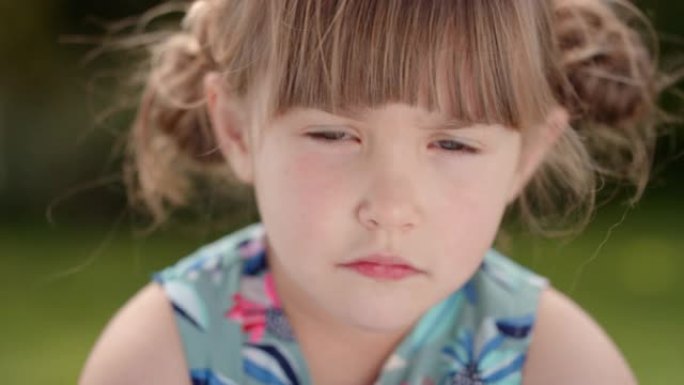 肖像美丽的小女孩看着相机带着好奇的表情可爱的孩子在阳光明媚的公园4k镜头