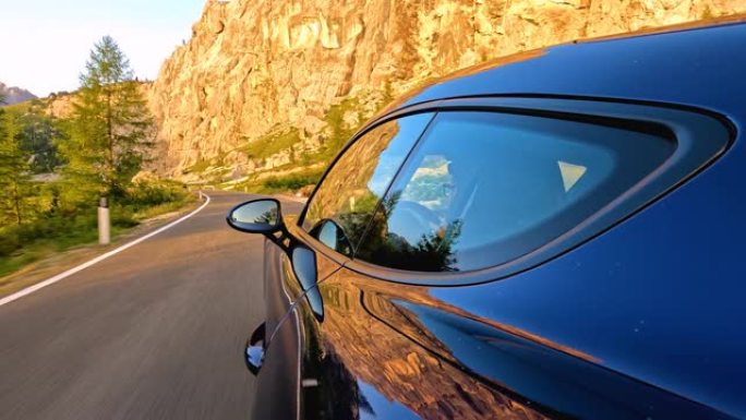 蓝色跑车在蜿蜒的山路上行驶，日落美景令人叹为观止