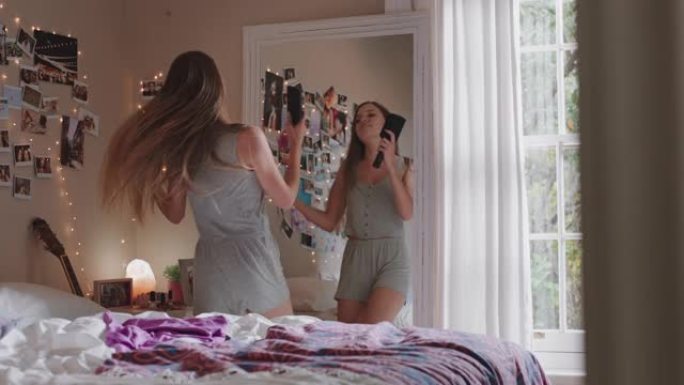 快乐的少女在卧室跳舞享受音乐庆祝周末快乐的青少年生活中穿着睡衣在家唱歌