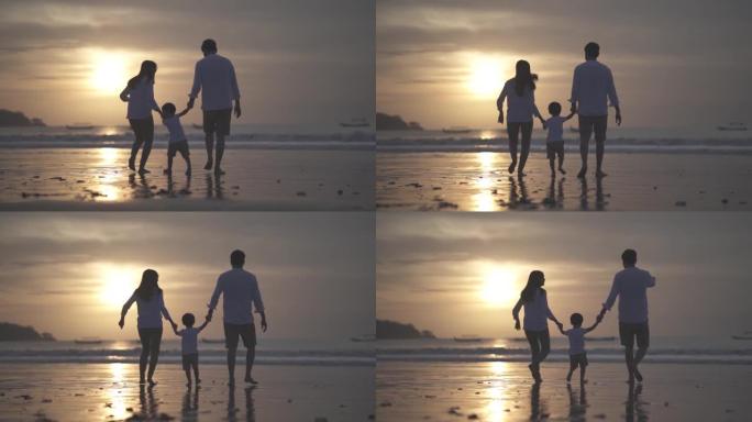 亚洲印尼幸福家庭父亲母亲和孩子在日落时在海滩上共度时光的肖像-关系，纽带，养育，笑和爱