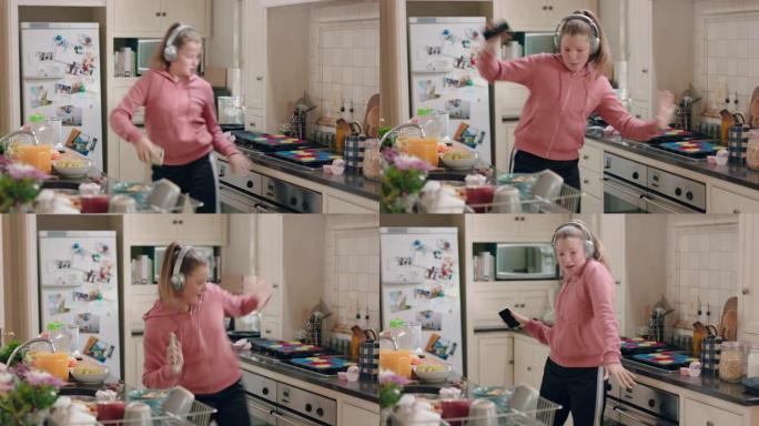 快乐的少女在厨房跳舞玩得开心庆祝周末表演有趣的舞蹈动作戴着耳机听音乐