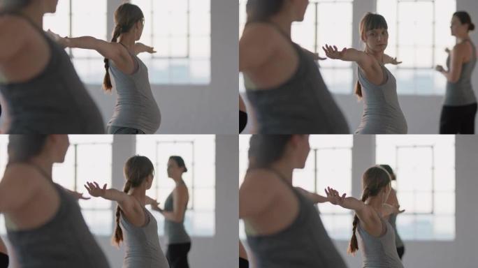 瑜伽课健康孕妇练习战士姿势享受日出时工作室教练的集体体能锻炼
