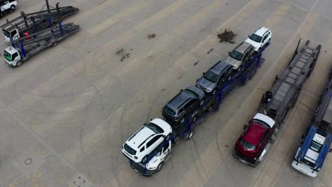 汽车运输商反向停车以在配送汽车中心卸载新车