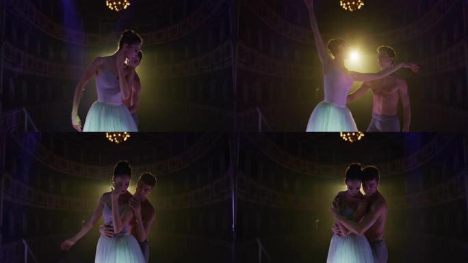 两名年轻的古典芭蕾舞演员在经典剧院的舞台上表演的电影镜头，并带有戏剧性的灯光。专业男女表演者优雅地排