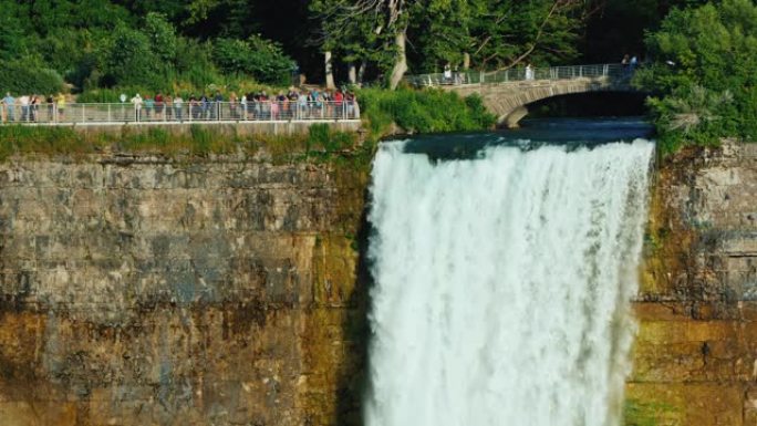 新娘的瀑布面纱和漫步在上面的游客。美国和加拿大边境著名的尼亚加拉瀑布