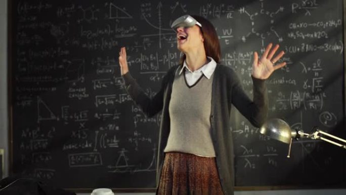 在黑板前使用VR蒙版和数学公式在大学教室中使用青年教师肖像。科学女研究员在使用技术，求解元宇宙中的方