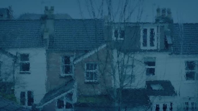 下雨的夜晚透过窗户看到的房子