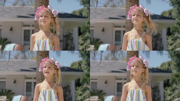 有趣的小女孩微笑着在户外散步，享受温暖的夏日，游泳池边可爱的孩子在家度假时戴着护目镜