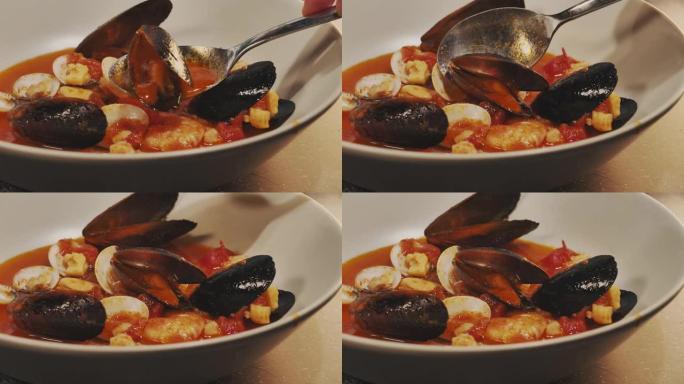 美味的鱼汤沸腾。在盘子里倒入一勺地中海鱼汤，贻贝，蛤。