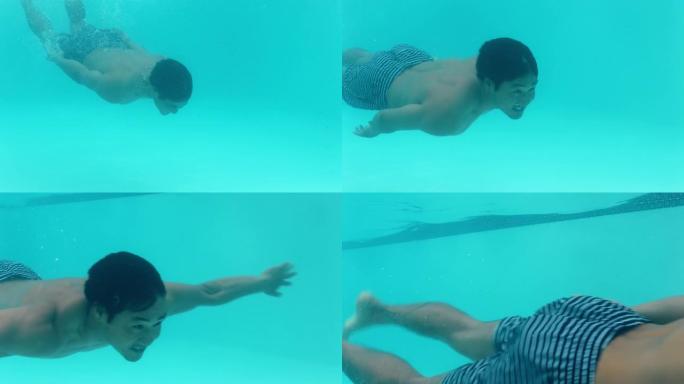 年轻的亚洲男子在游泳池水下游泳漂浮在蓝色水晶清澈的水中玩得开心夏天4k