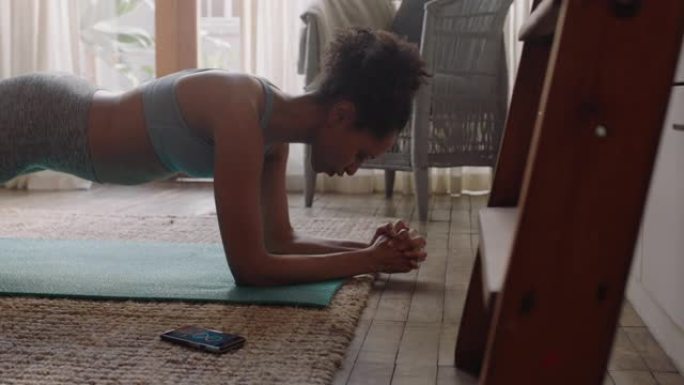 健康的女人在家锻炼，在客厅练习，享受早上的健身锻炼