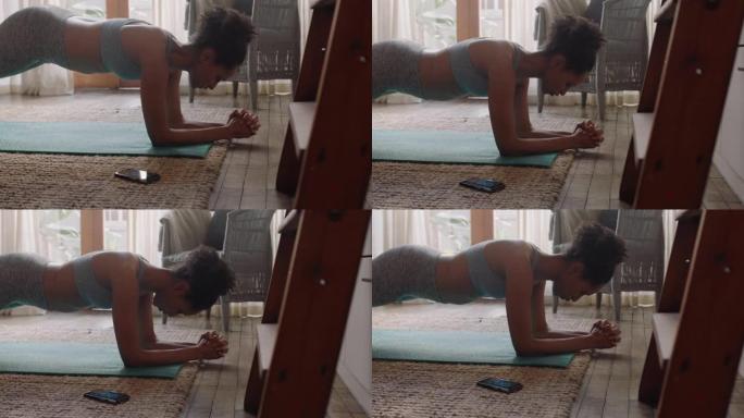 健康的女人在家锻炼，在客厅练习，享受早上的健身锻炼