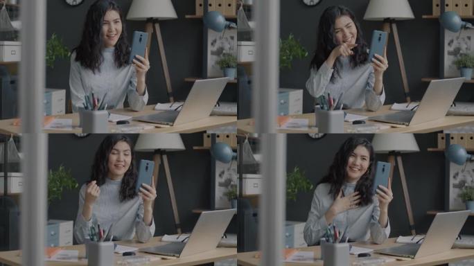 迷人的亚洲女商人在办公室在线视频通话中聊天和挥手的肖像