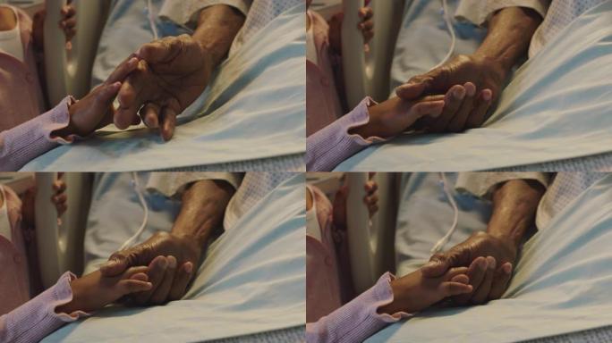 小女孩牵着爷爷的手爷爷躺在医院的病床上，孩子在床边对从疾病中康复的祖父母表示爱意。医疗保健家庭支持