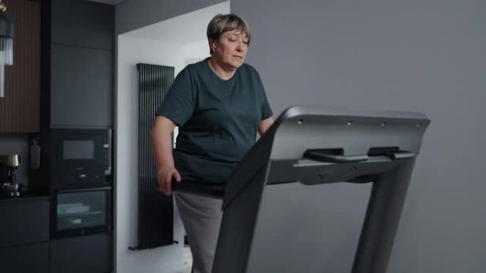 在家跑步机上进行有氧运动，老年妇女进行减肥和预防疾病的训练