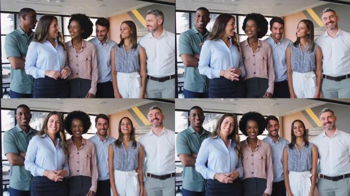 微笑的多元文化商业团队站在现代办公室的肖像