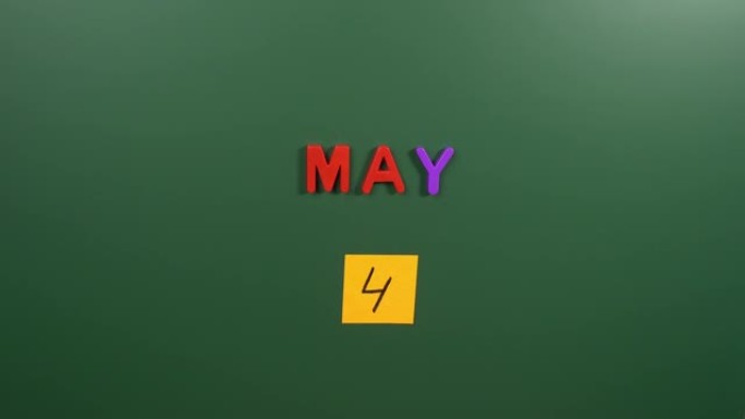5月4日日历日用手在学校董事会上贴一张贴纸。5月4日。五月的第四天。第四个日期号。4天日历。四次约会