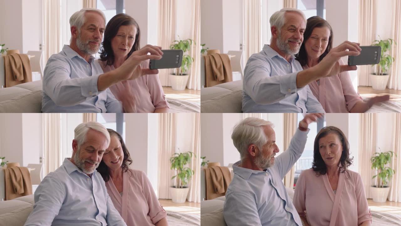 快乐的中年夫妇使用智能手机视频聊天吹吻孙子享受在线交流放松退休之家