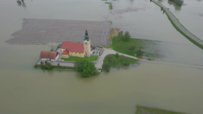 空中: 乡村教堂和公墓被洪水淹没的农田包围