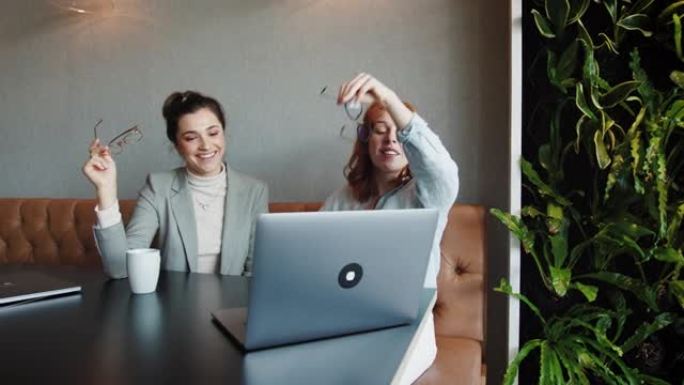 商业女性在笔记本电脑上聊天和观看幻灯片