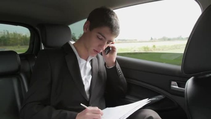 忙碌的商人在汽车上拿着文件和手机