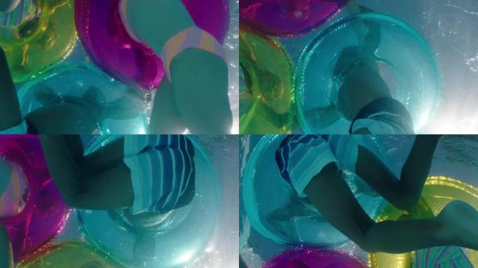 儿童在游泳池里泼水，带多色游泳管充气玩具嬉戏地玩乐在水上漂浮享受暑假水下景观