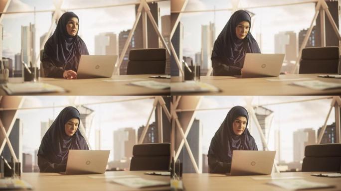 授权一位戴着头巾的穆斯林女商人的肖像，在金融科技初创公司的笔记本电脑上工作。阿拉伯金融分析师在新兴的