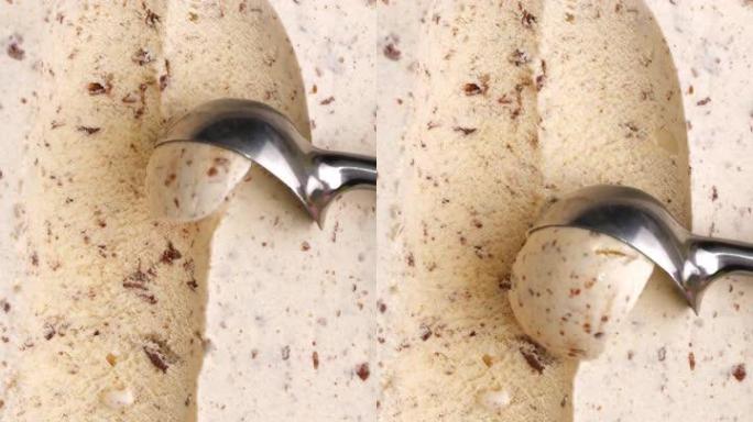 用铁勺将巧克力味的冰淇淋sc入球。
