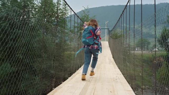 快乐游客跑山河大桥。兴奋的女孩跳上大自然。