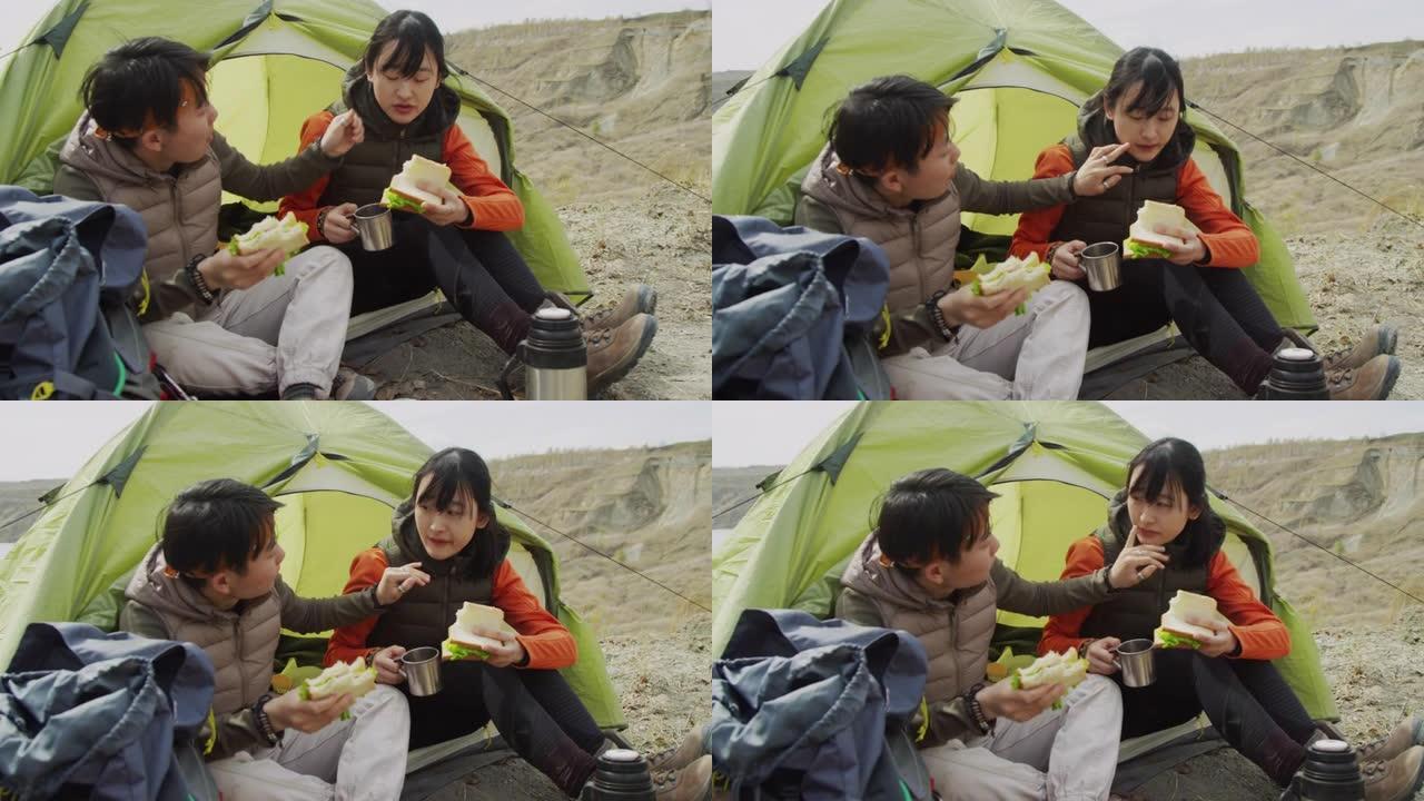 两个亚洲女性朋友在岩石湖海岸徒步旅行时共进午餐