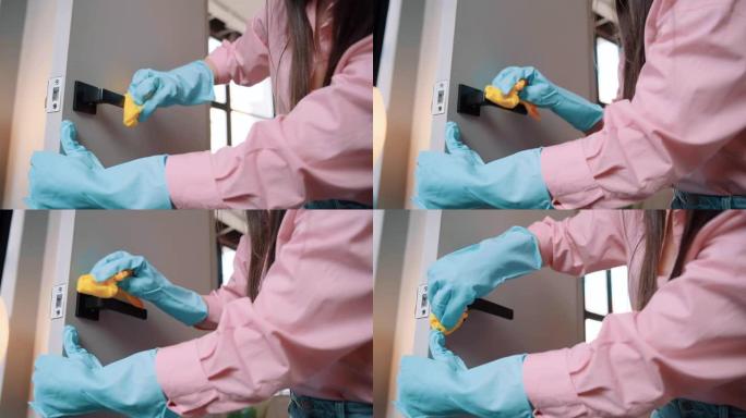 一只手在橡胶手套清洁门把手的特写镜头。家庭主妇在酒店洗门。看门人或专业清洁团队消毒家具