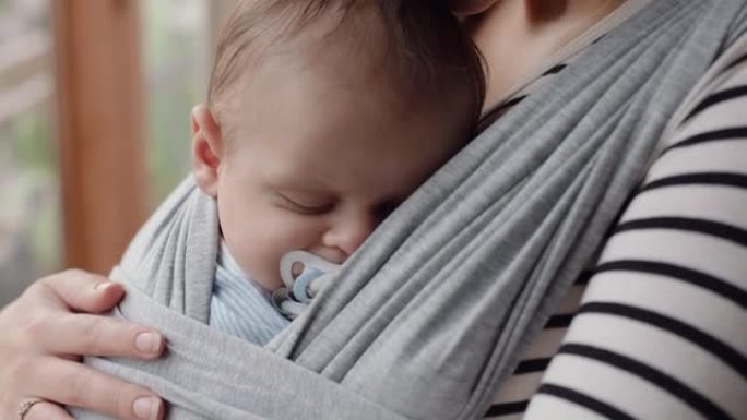 年轻的母亲抱着熟睡的婴儿望着窗外，思考孩子的未来计划，拥抱母亲的责任