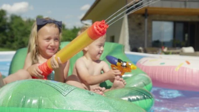 特写: 可爱的女孩和男孩在阳光明媚的夏日在游泳池里玩得开心