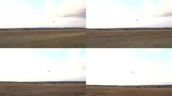 带有螺旋桨发动机的小型飞机在湛蓝的天空中飞行。在乡村机场上空轻量飞机飞行的鸟瞰图。乘坐超轻运动飞机旅