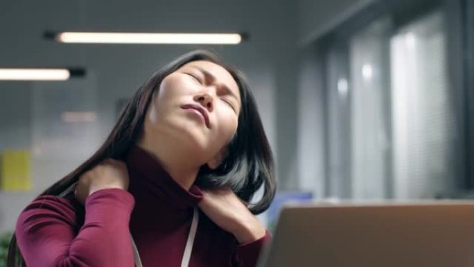 亚洲女商人在电脑前工作时感到脖子痛