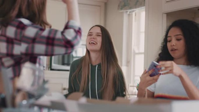 快乐的十几岁的女孩在厨房跳舞，吃披萨玩得开心，一起庆祝享受周末的闲逛