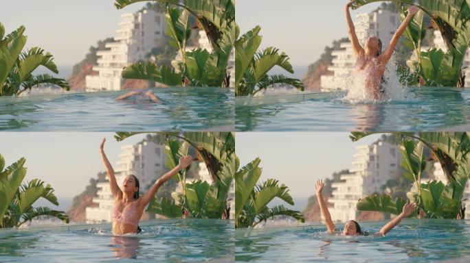 美丽的女人从游泳池水中跳出来，双臂举起，在地中海酒店度假胜地享受暑假，日落时可以看到海洋，旅行自由4