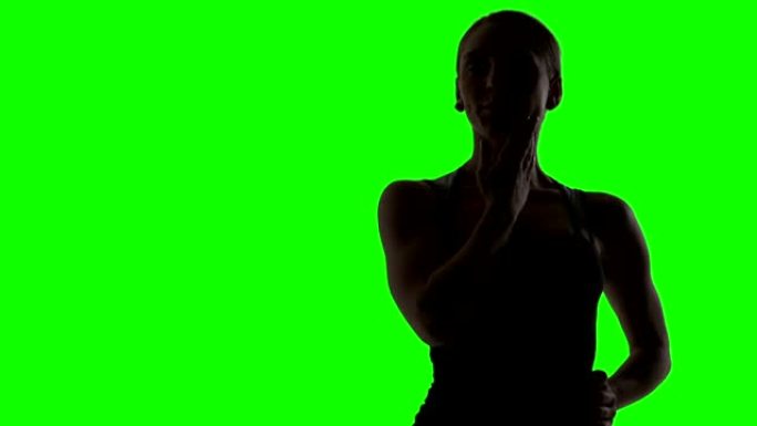 年轻女子跳舞的剪影。绿屏