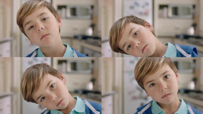 肖像快乐的小男孩看着相机带着好奇的表情可爱的孩子在厨房里