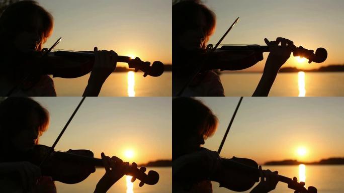 女小提琴手在日落时在湖边拉小提琴